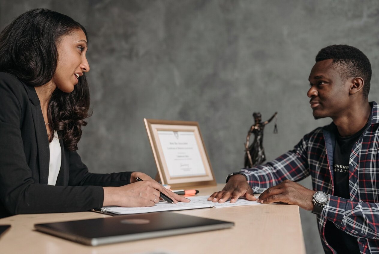 Two people reviewing relocation paperwork together at a meeting table