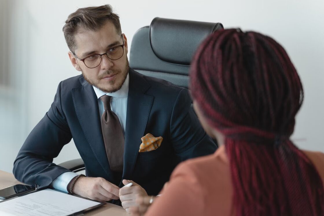 An adviser and a client discussing a relocation plan across a desk